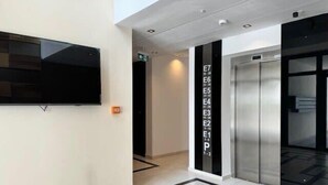Een moderne lift met een digitaal scherm dat de verdiepingen aangeeft en een bedieningspaneel.