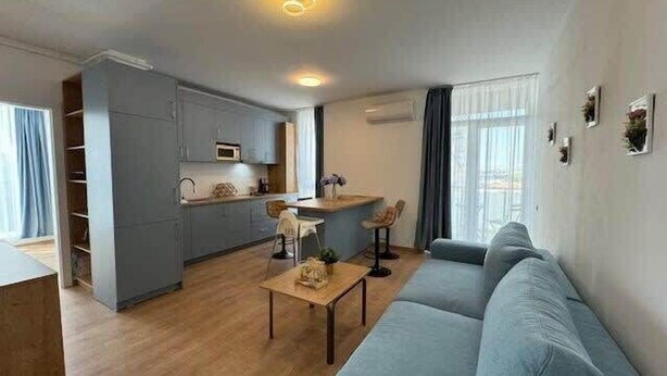 Een modern appartement met keuken, eethoek en woonkamer.