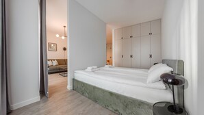 Une chambre à coucher moderne avec un lit, une table de chevet, une lampe et une armoire.