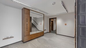 Un intérieur moderne avec un mur d’accent en bois, un escalier et un design épuré et minimaliste.