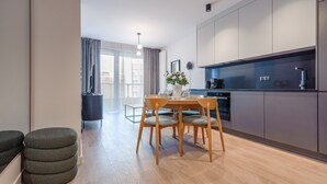Une cuisine moderne avec un coin repas, des meubles en bois et une vue sur la ville.