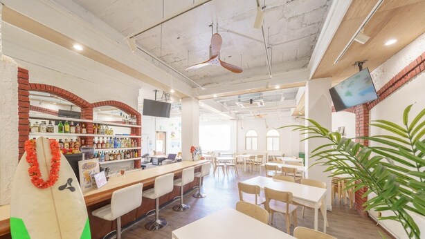 A restaurant with a bar area, seating, and a large plant. - pension Aloalo (Shirahama)