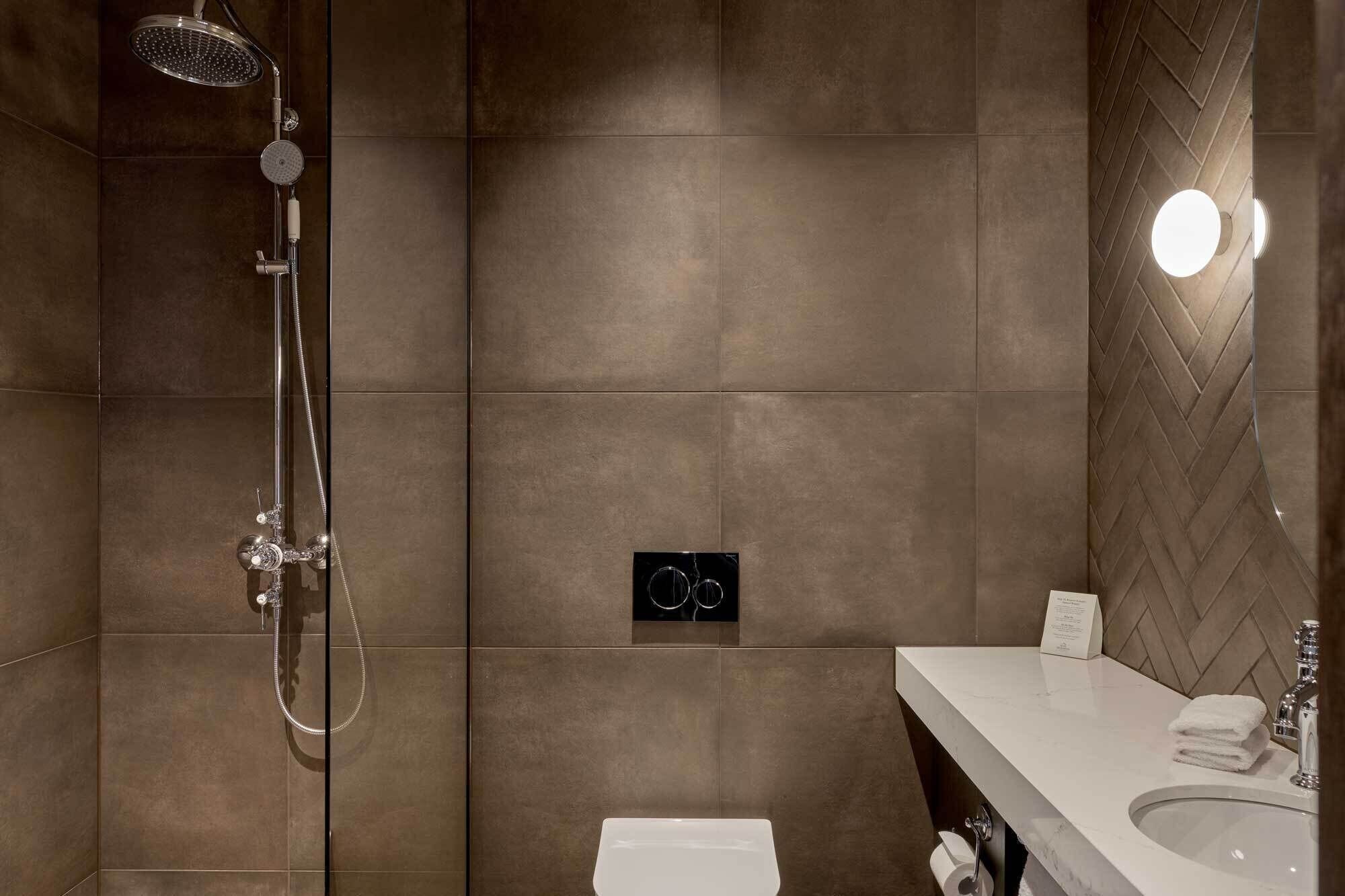 Un baño moderno con ducha, inodoro y lavamanos.