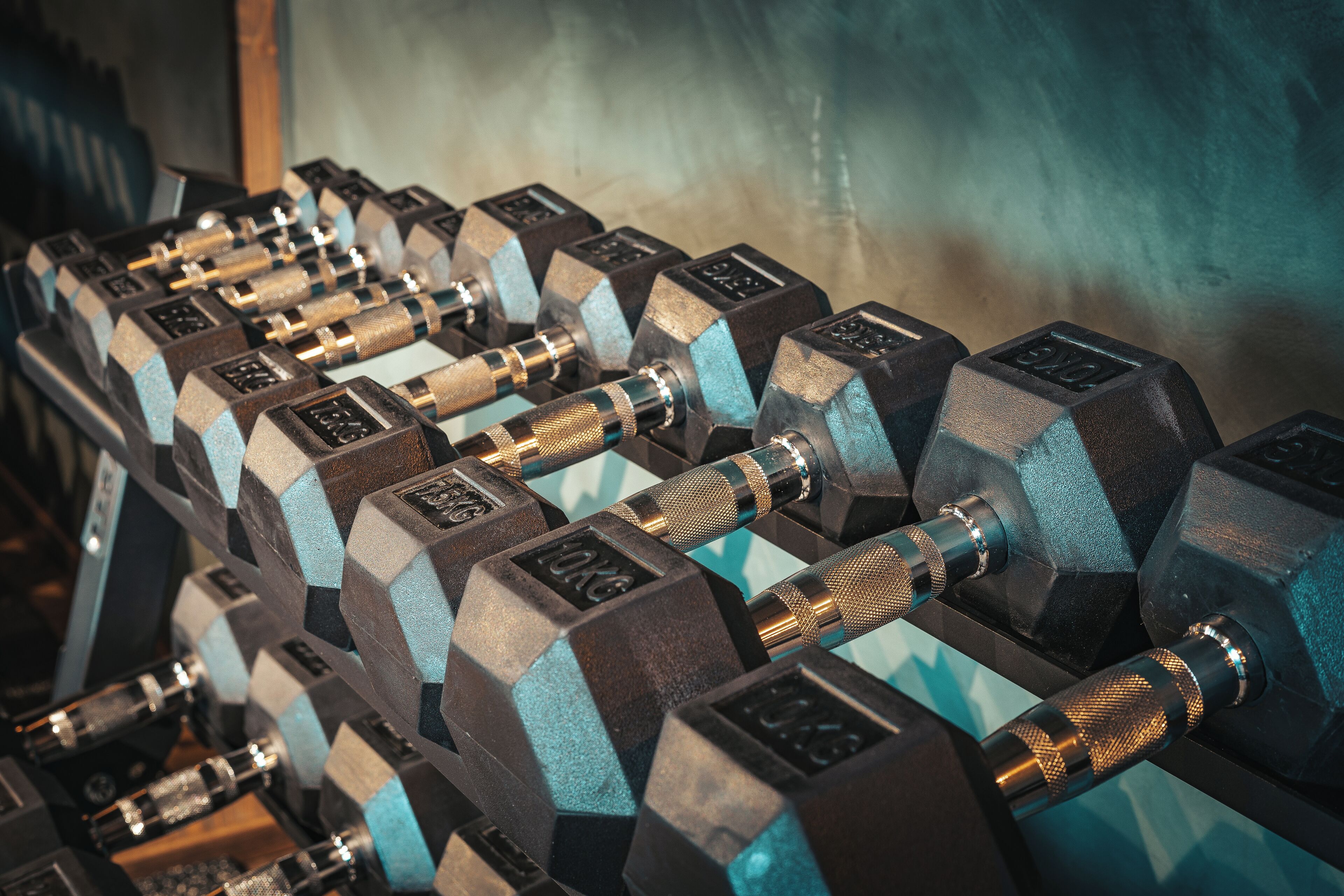 A set of black and blue dumbbells arranged on a rack.
