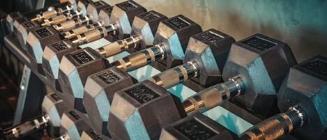 A set of black and blue dumbbells arranged on a rack.