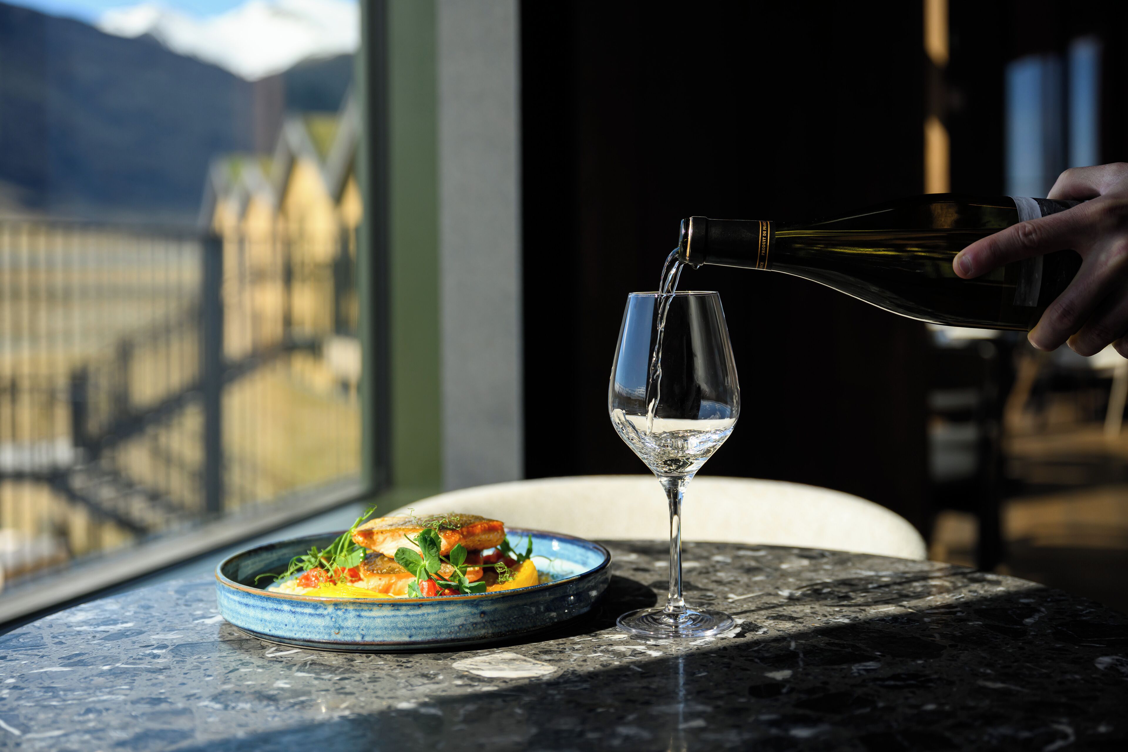 A table with a plate of food and a wine glass.
