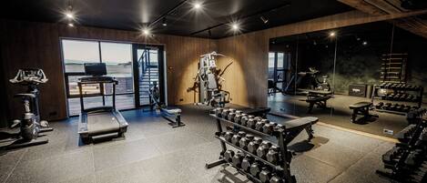 A gym with exercise equipment, a treadmill, and a view of the outdoors.