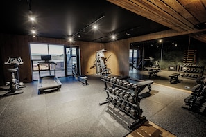 A gym with exercise equipment, a treadmill, and a view of the outdoors.
