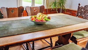 A wooden dining table with a bowl of fruit in the center. - Alandblick Inn (Wanzer)