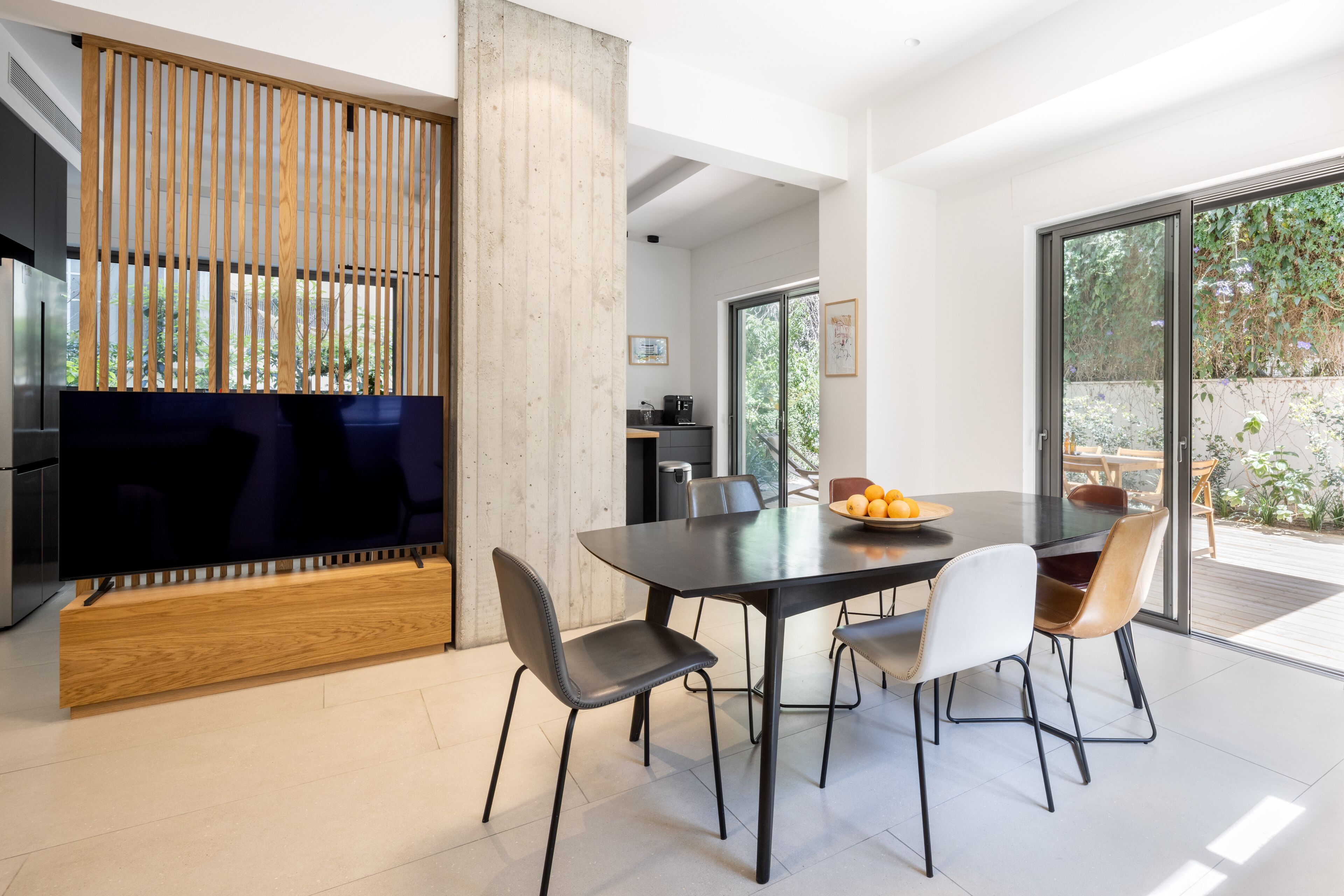 Un comedor moderno con una mesa grande, sillas y un televisor.