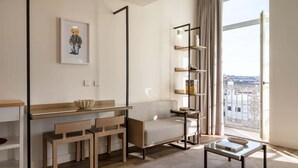 Una sala de estar moderna con un sofá, una mesa de centro, una estantería y un escritorio con sillas.