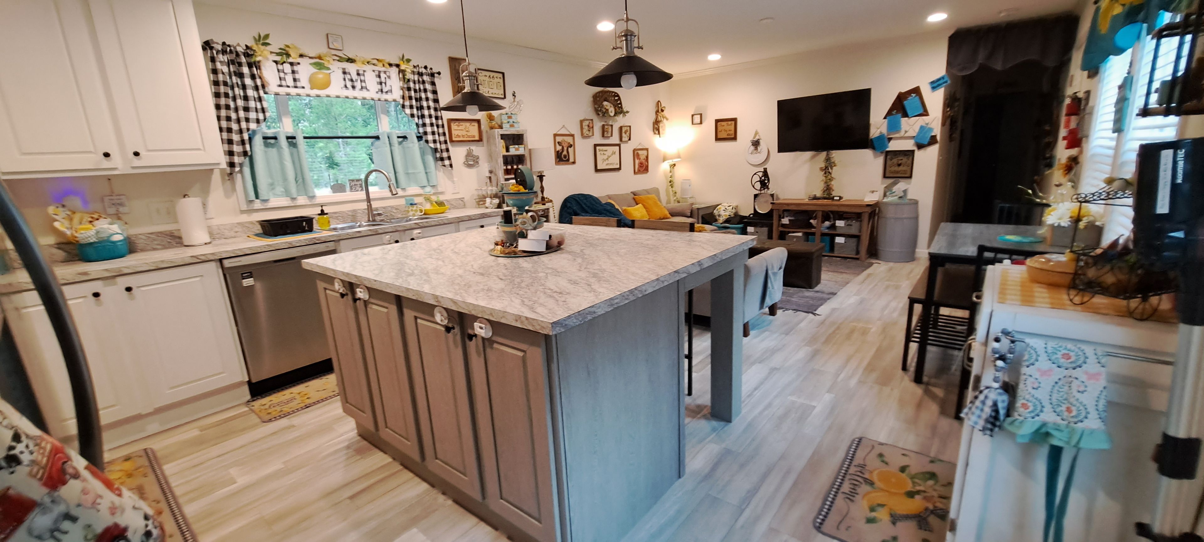 Een moderne keuken met een centraal kookeiland, inbouwapparatuur en een eethoek met een tafel en stoelen.
