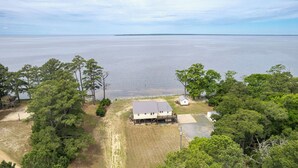 Une maison dotée d’une grande terrasse et offrant une vue sur un lac.