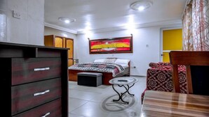 Ein Schlafzimmer mit Bett, Nachttisch, Kommode und einem Bild an der Wand.