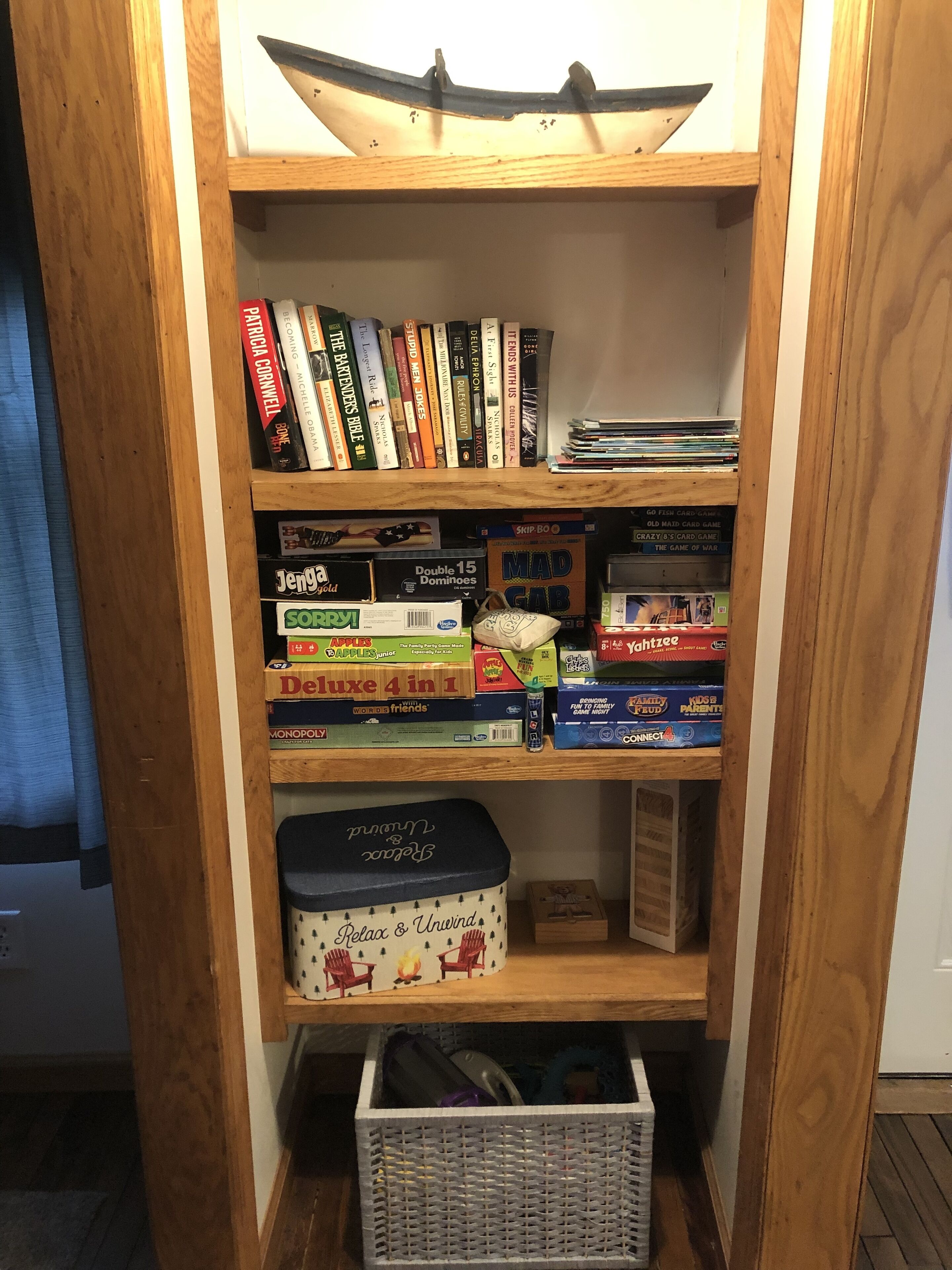 A bookshelf with various board games and books.
