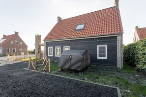 A house with a red-tiled roof, a wooden exterior, and a small window.