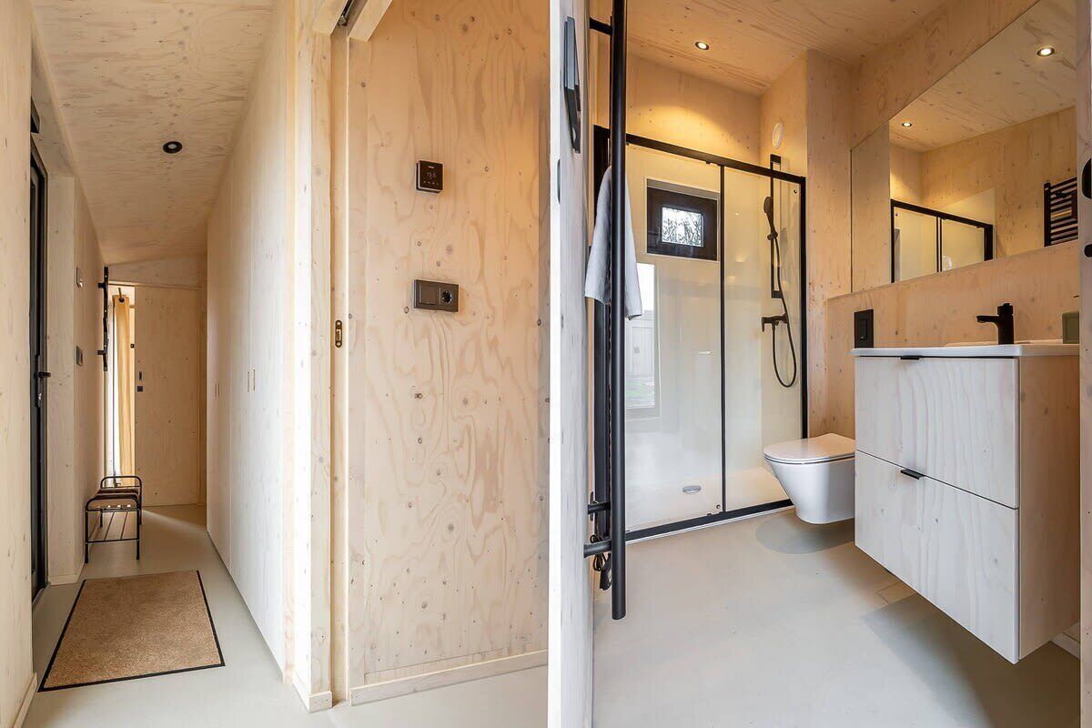 Een moderne badkamer met douche, toilet en wastafel.