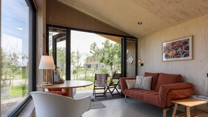 Ein modernes Interieur mit einer Couch, einem Sessel, einem Tisch und einer Lampe.
