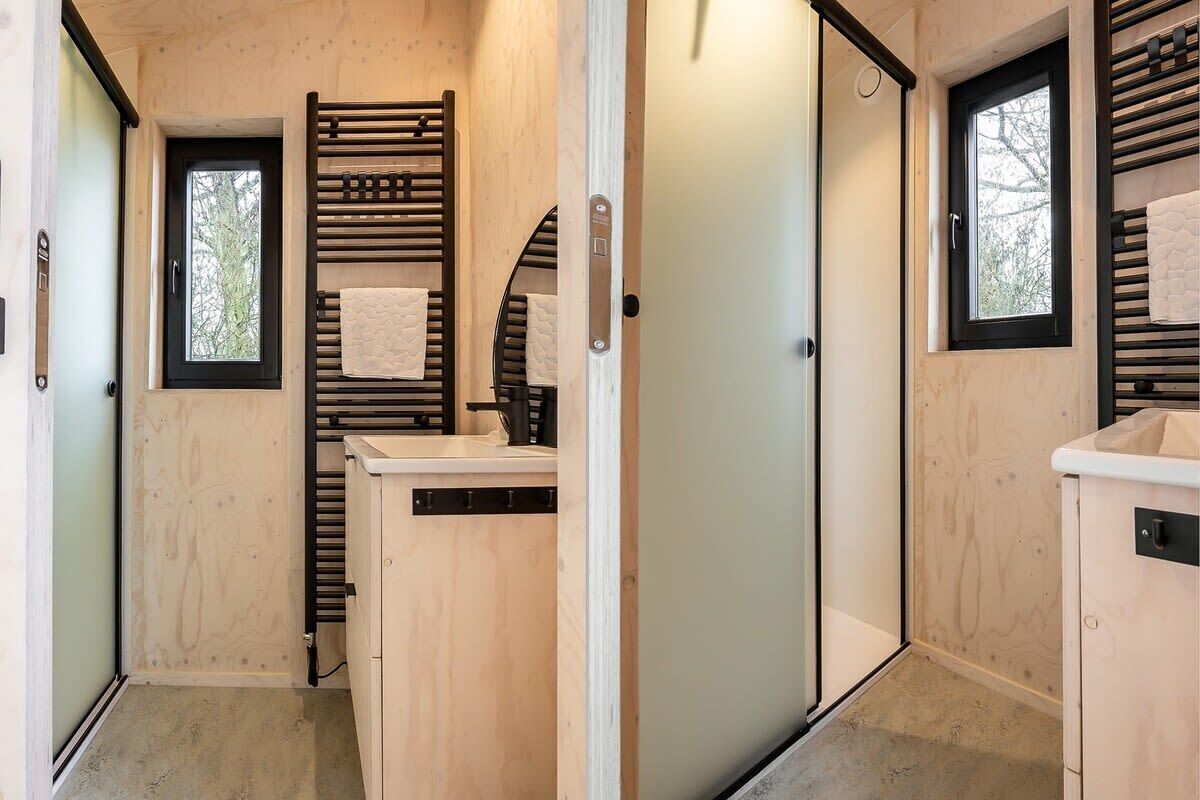 A compact bathroom with a towel rack, a sink, and a window.