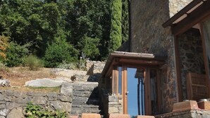 A stone building with a wooden door and a small porch area. - Casa Foglia Verde - Immersa nel Parco (Liguria)