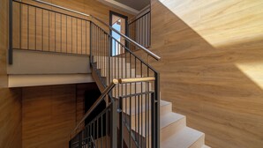 A modern staircase with wooden walls and metal railings.
