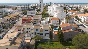 Une ville côtière aux bâtiments blancs, dotée d’une tour imposante et offrant une vue dégagée sur la mer.