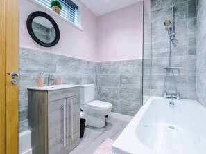 Ein modernes Badezimmer mit Toilette, Waschbecken und Badewanne.