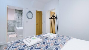 Een moderne slaapkamer met een bed, een houten deur, een zwarte hanger en een douche.