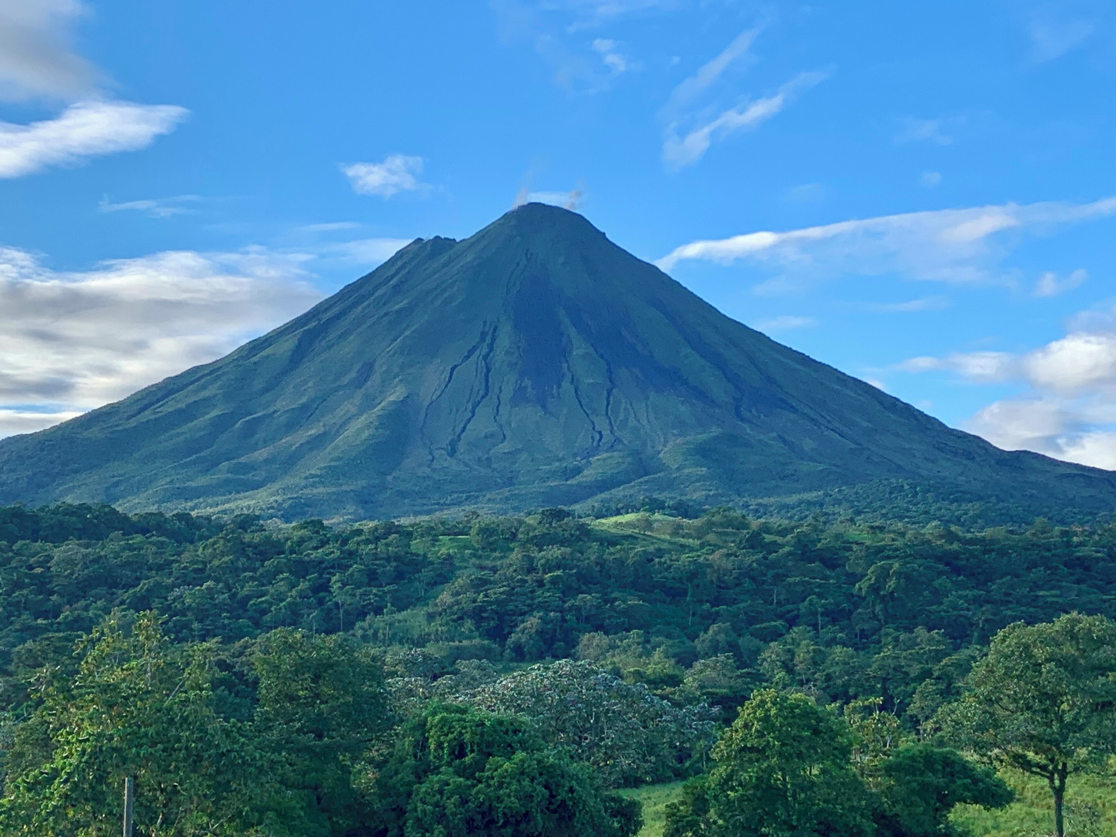 Una montaña de forma cónica con una base boscosa.