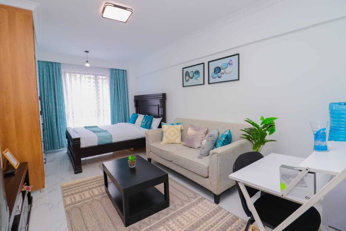 Une chambre à coucher moderne avec un lit, un canapé, une table basse et un bureau.
