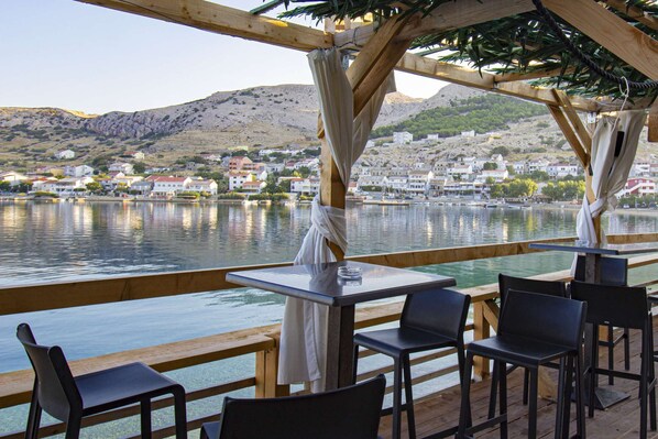 Dine al fresco with a view of the serene lake and picturesque hillside town.