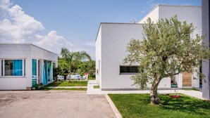 A modern building with a clear sky, a tree, and a pathway.