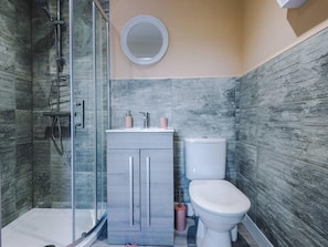 A modern bathroom with a glass-enclosed shower, a toilet, and a vanity with a mirror. - One-bedroom by Media City UK by Belvilla (Manchester)