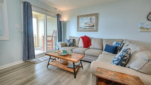 Ein Wohnzimmer mit einer Couch, einem Couchtisch und einem Gemälde an der Wand.