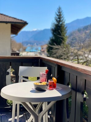 Un balcón con una mesa, un cuenco y dos bebidas.