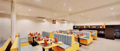 A restaurant with multiple seating areas, including booths and tables, with a clean and modern interior.