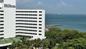 Un hotel Hilton blanco con vista al océano y un barco a lo lejos.