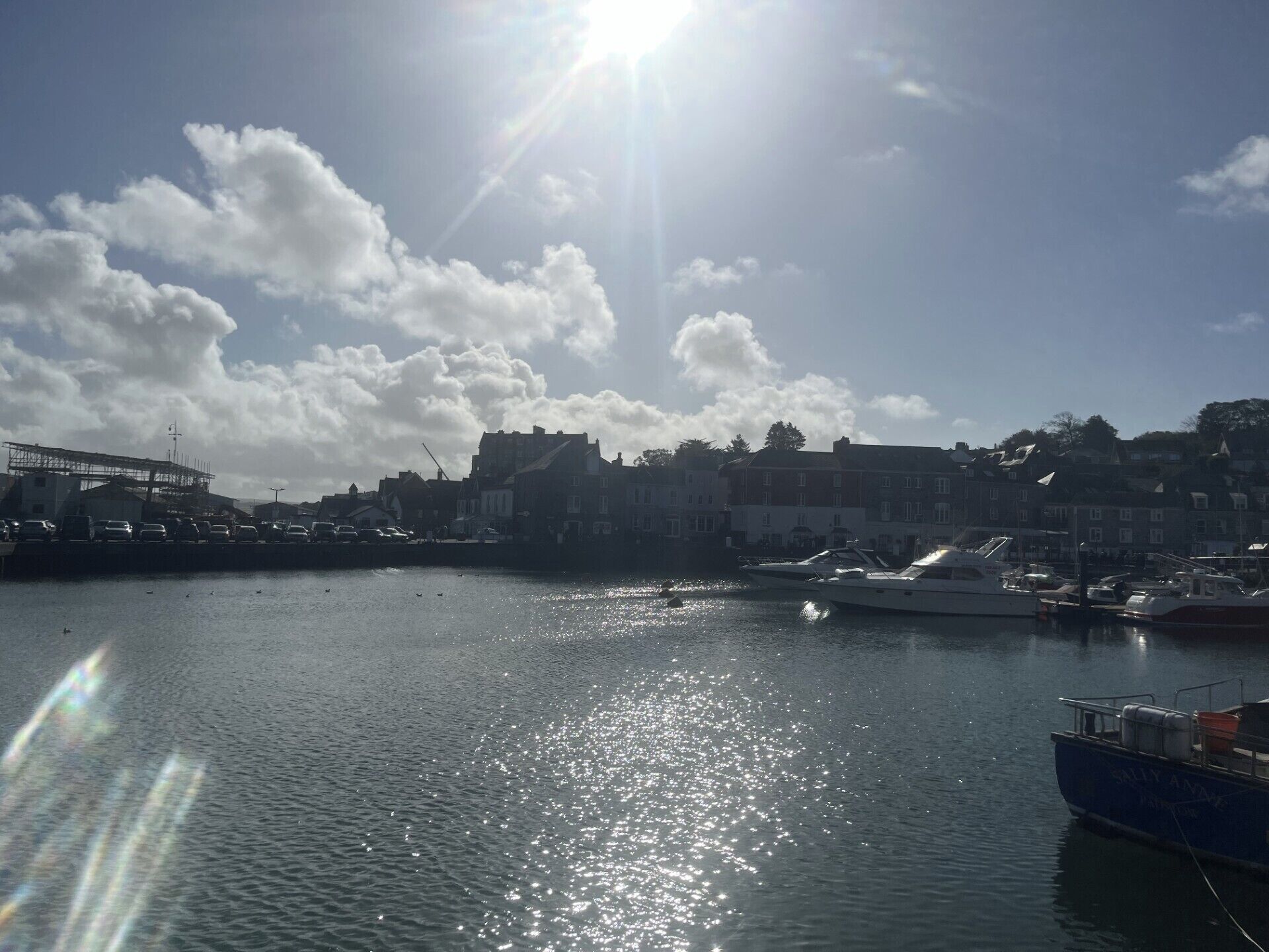 A harbor with boats, a clear sky, and buildings in the background.