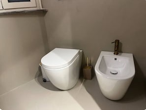 Een douche, een haardroger, een bidet, handdoeken
