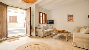 A living room with a sofa, a coffee table, and a television. - Petra holiday home by Rentallorca (Petra)