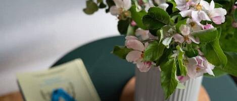 Una planta en maceta con flores rosadas sobre una mesa.