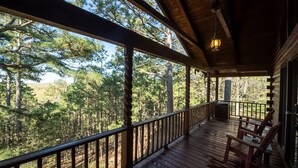 A wooden deck with a railing, overlooking a forested area. - Heart Shaped Tub for Two, Cabin, Views for miles! (Eureka Springs)