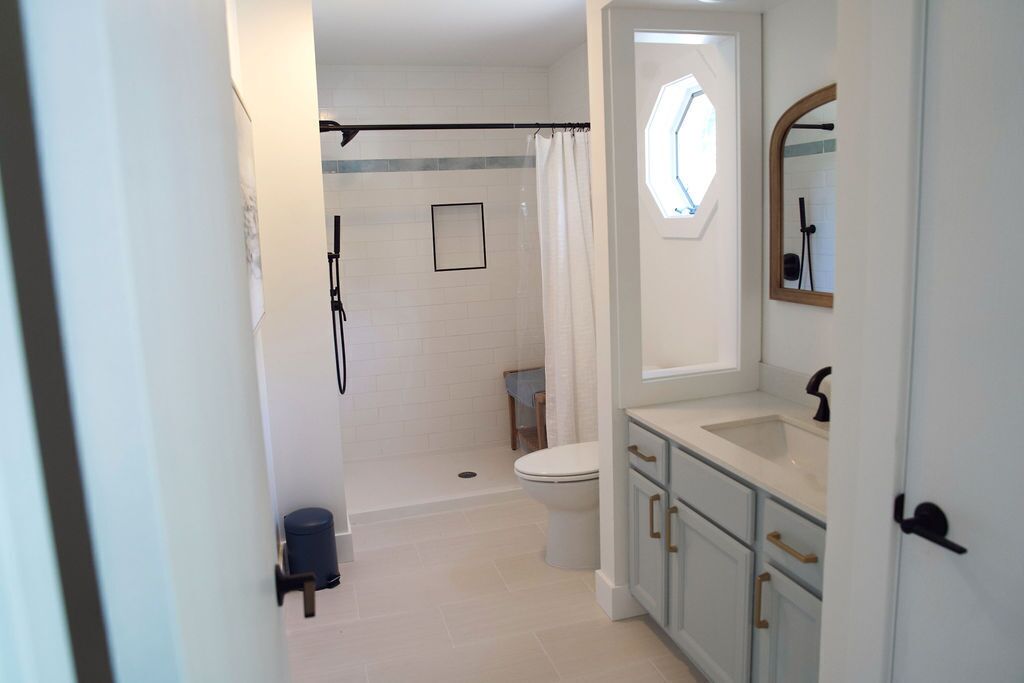 Une salle de bain avec douche, toilettes et lavabo.
