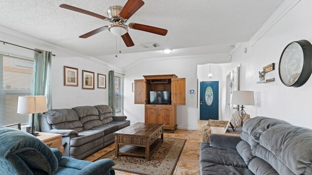 A living room with a ceiling fan, a sofa, a coffee table, and a cabinet.