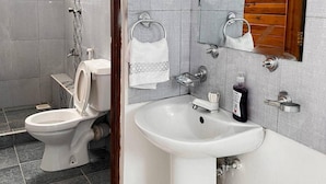 Ein Badezimmer mit Toilette, Waschbecken und Spiegel.