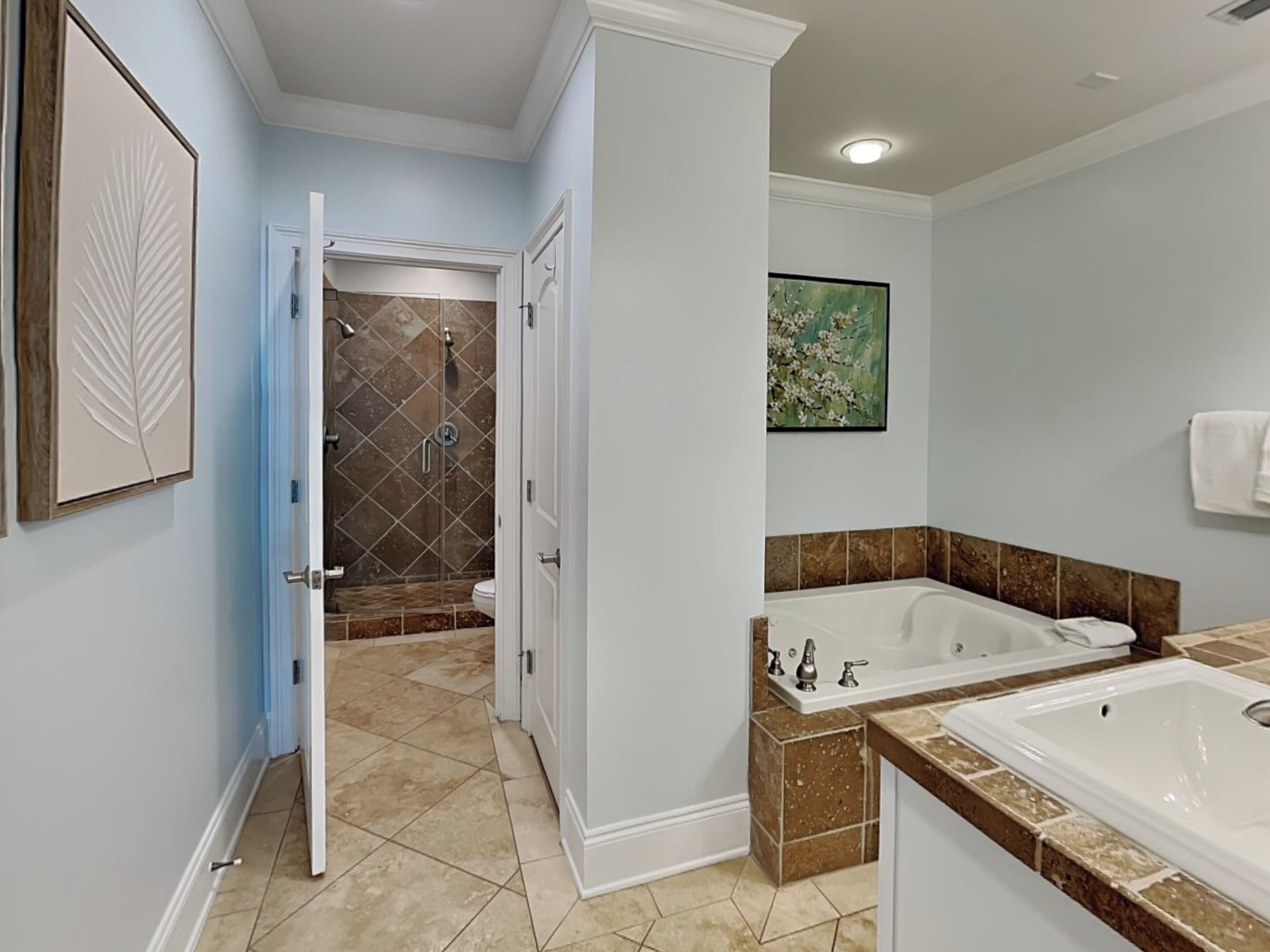 A modern bathroom with a walk-in shower, a large bathtub, and a sink.
