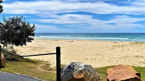 A beach with a clear view of the ocean, a fence, and large rocks in the foreground. - Charming Beach Getaway -Tucked away in Valla beach is the charming home that has a unique private ba (Valla Beach)