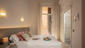 A hotel room with a bed, bedside table, and a breakfast tray on the bed. - Antonios Hostal (Sitges)