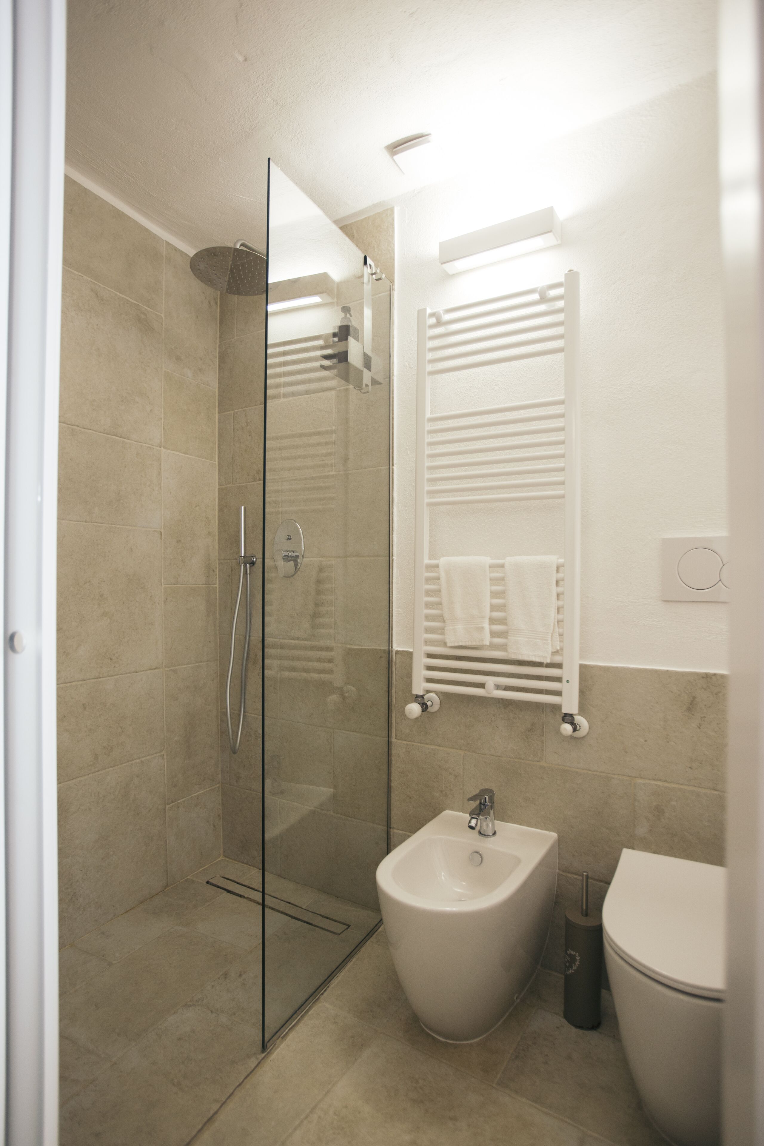 Un baño moderno con ducha acristalada, un bidé y un inodoro.