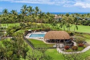 Un resort con piscina, un pabellón techado y vista al océano.